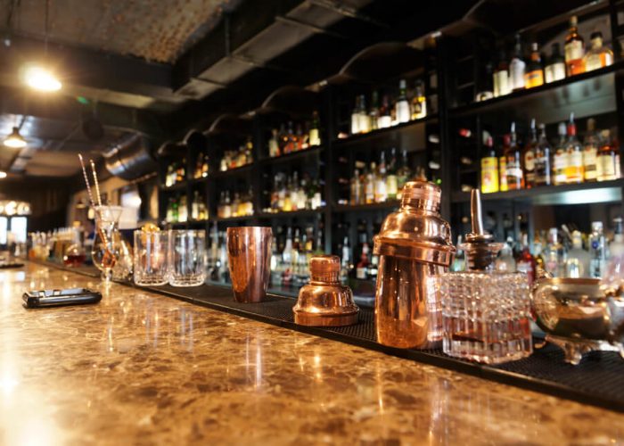 Different types of glasses and shaker on a marble bar table